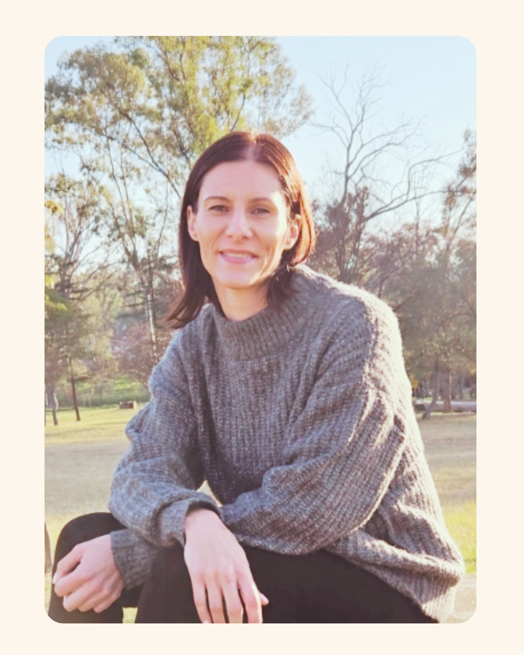 Claire, coach for women in midlife, smiling in a park in soft afternoon light